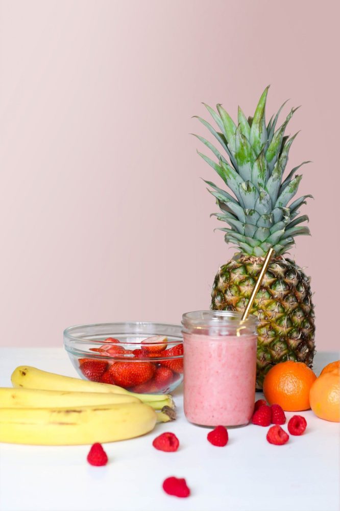 Piña junto a un batido de fresa, platanos y otras frutas, fomentando una nutrición saludable